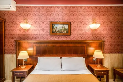 a bedroom with a bed with two night stands and two lamps at Hotel Aurelius in Rome