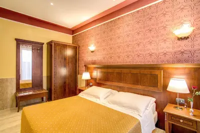 a bedroom with a bed and a red wall at Hotel Aurelius in Rome
