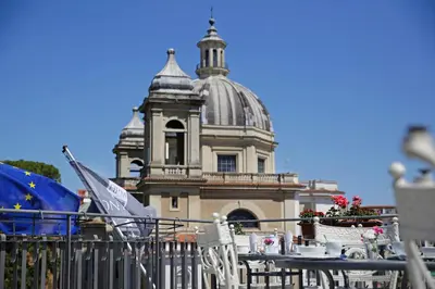a building with a table and chairs in front of it at BeYou Hotel Ponte Milvio in Rome