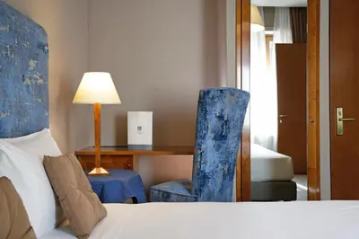 a bedroom with a bed and a desk and a chair at BeYou Hotel Ponte Milvio in Rome