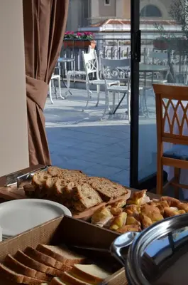 a tray of bread and pastries on a table at BeYou Hotel Ponte Milvio in Rome