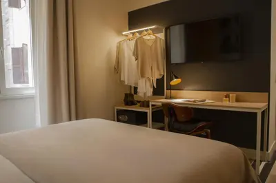 a hotel room with a bed and a desk and a mirror at room Select Via Veneto in Rome