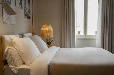 a bedroom with a bed with white pillows and a lamp at room Select Via Veneto in Rome