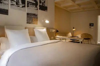 a bedroom with a large white bed and a desk at room Select Via Veneto in Rome