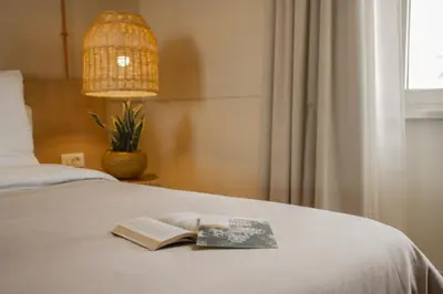 a book sitting on top of a bed with a lamp at room Select Via Veneto in Rome