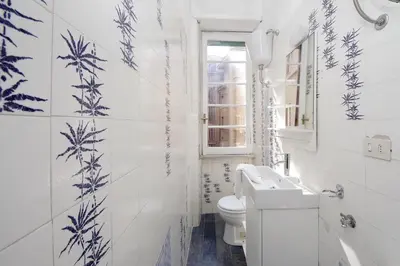 a bathroom with blue and white walls and a toilet at 4BNB - Chinotto Spacious Apartment in Rome