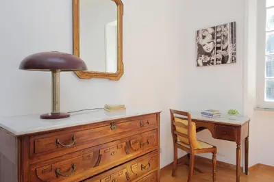 a dresser with a lamp and a desk with a chair at 4BNB - Chinotto Spacious Apartment in Rome