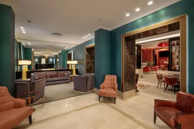 a lobby with blue walls and chairs and a waiting room at Hotel Diana Roof Garden in Rome