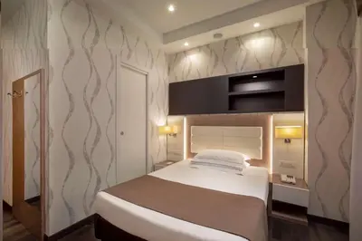 a bedroom with a white bed and a wall at Hotel Diana Roof Garden in Rome