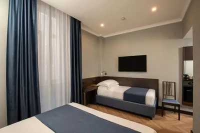 a hotel room with two beds and a television at Hotel Diana Roof Garden in Rome