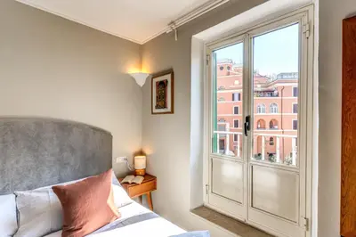 a bedroom with a bed and a large window at RR Apartments San Giovanni in Rome