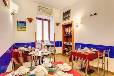 a restaurant with two tables and chairs and a book shelf at Hotel Gea Di Vulcano in Rome