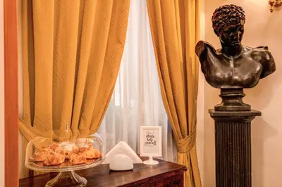 a statue sitting on a table next to a window at Hotel Gea Di Vulcano in Rome