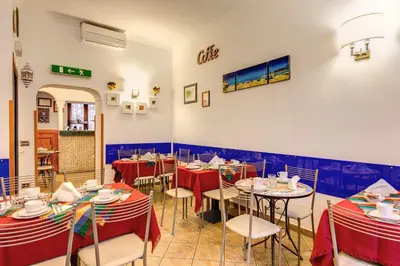 a dining room with tables and chairs with red table cloth at Hotel Gea Di Vulcano in Rome