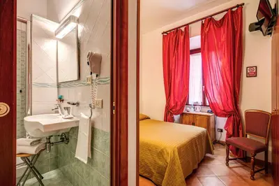 a bathroom with a bed and a sink in a room at Hotel Gea Di Vulcano in Rome