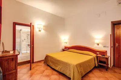 a bedroom with a bed and a window and a mirror at Hotel Gea Di Vulcano in Rome