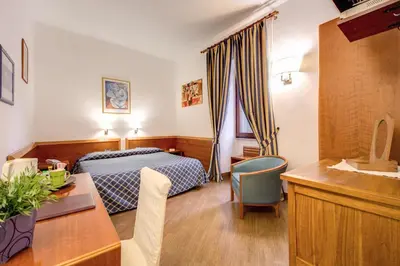 a hotel room with a bed and a desk at Hotel Gea Di Vulcano in Rome