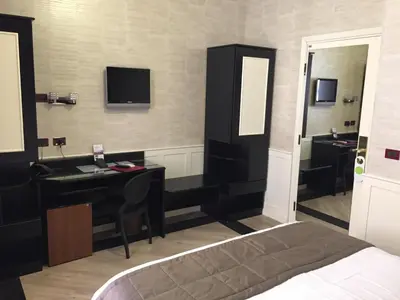 a bedroom with a bed and a desk and a mirror at Hotel Museum in Rome