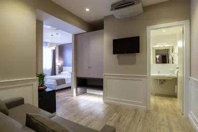 a living room with a couch and a tv on the wall at Hotel Museum in Rome