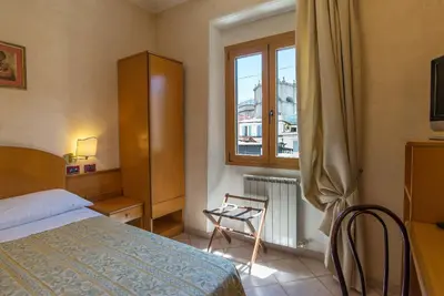 a bedroom with a bed and a window and a chair at Hotel Museum in Rome