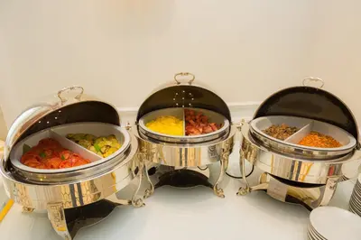 three food pans filled with different types of food at Hotel Milton Roma in Rome