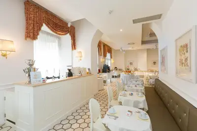 a restaurant with white tables and chairs and a counter at Hotel Milton Roma in Rome