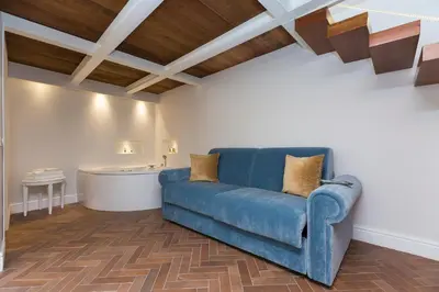 a blue couch in a living room with wooden ceilings at Hotel Milton Roma in Rome