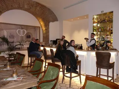 a group of people sitting at a bar in a restaurant at Hotel Milton Roma in Rome