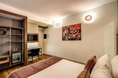 a living room with a bed and a desk at Al Manthia Hotel - Gruppo Trevi Hotels in Rome