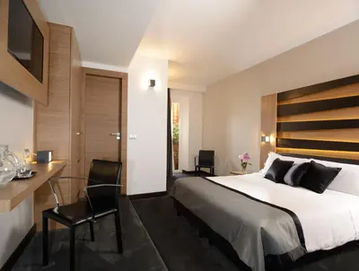 a bedroom with a large bed and a desk and chairs at Hotel Trevi - Gruppo Trevi Hotels in Rome