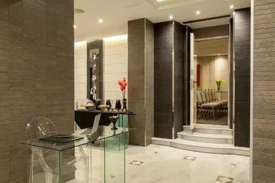 a lobby with a glass table and a staircase at Hotel Ariston in Rome