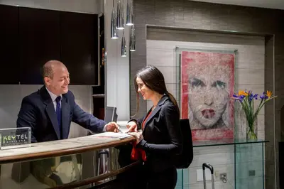 a man and a woman standing at a counter at Hotel Ariston in Rome