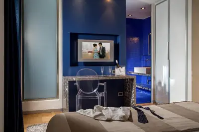 a bedroom with a bed and a tv on a blue wall at Hotel Ariston in Rome