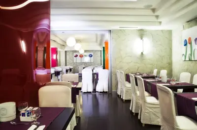 a dining room with tables and white chairs at Hotel Ariston in Rome