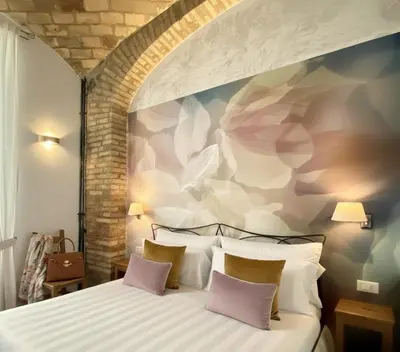 a bedroom with a bed with a flower mural on the wall at Le Clarisse Trastevere in Rome