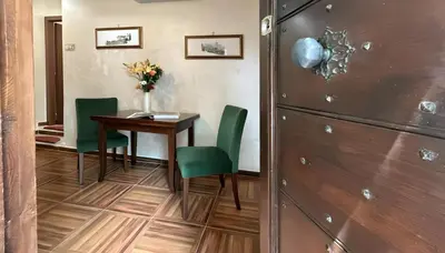 a room with a table and green chairs and a door at Le Clarisse Trastevere in Rome