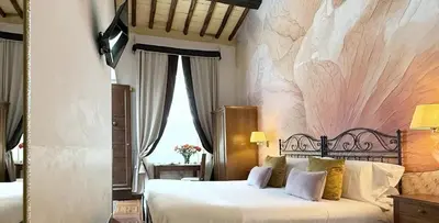 a bedroom with a large bed and a wall mural at Le Clarisse Trastevere in Rome