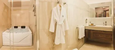 a bathroom with a white robe and a sink at Le Clarisse Trastevere in Rome