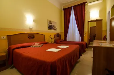 a hotel room with two beds with red sheets at Hotel Cherubini in Rome