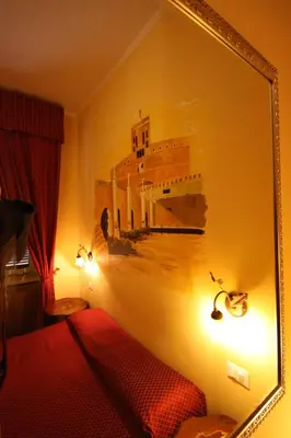 a mirror hanging on a wall in a bedroom at Hotel Cherubini in Rome