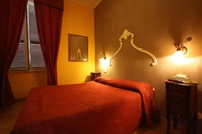 a bedroom with a bed with a red comforter at Hotel Cherubini in Rome