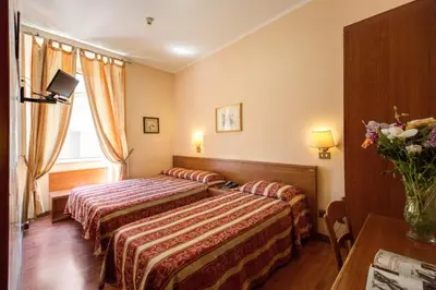 a hotel room with two beds and a table at Buonarroti Home in Rome