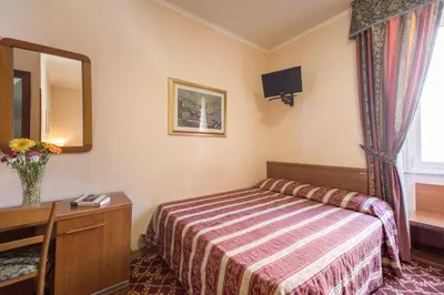 a hotel room with a bed and a mirror at Buonarroti Home in Rome