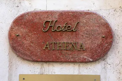 a rusty sign that reads hotel athena on a wall at Albergo Athena in Rome