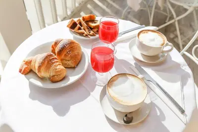a table with plates of croissants and a cup of coffee at Albergo Athena in Rome