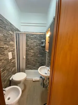 a bathroom with two sinks and a toilet and a shower at Albergo Athena in Rome