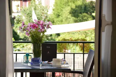 a table with a vase of flowers on a balcony at LH Hotel Lloyd Roma in Rome