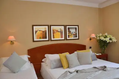 two beds in a bedroom with pictures on the wall at LH Hotel Lloyd Roma in Rome