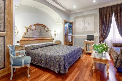 a bedroom with a large bed and a chair at Hotel Villa San Pio in Rome