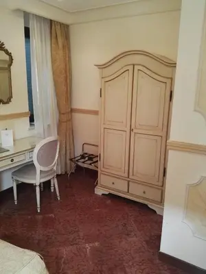 a bedroom with a desk and a cabinet and a chair at Hotel Villa San Pio in Rome